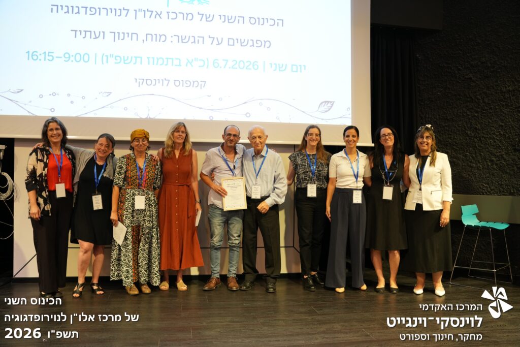 גיא אסל מקבל פרס הוא על הבמה עם חברי מרכז אלון