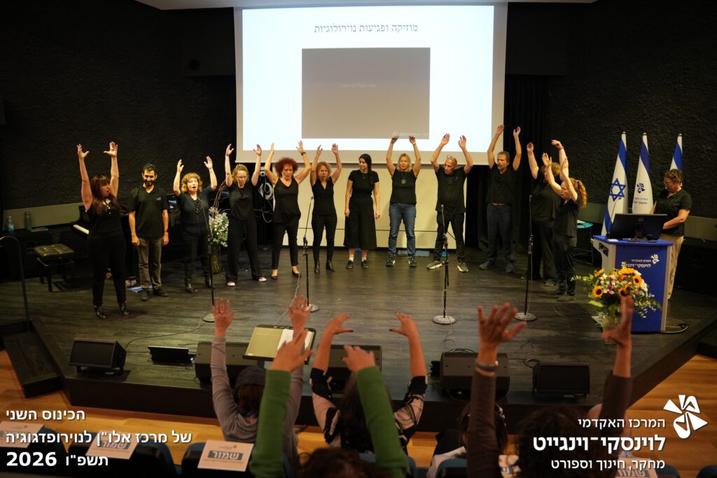 מקהלה שרה על הבמה עם ידיים למעלה וגם בקהל שרים עם ידחחם למעלה